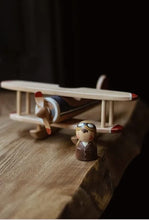Load image into Gallery viewer, Small wooden airplane model on a wooden surface with a dark background
