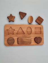 Load image into Gallery viewer, Wooden shape sorting toy with various wooden shapes on a gray background
